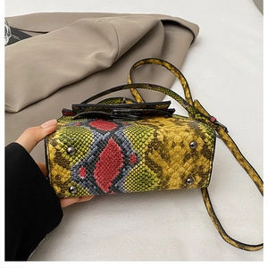 Detail of the multi-colored snakeskin crossbody bag with metal bottom feet and slim strap