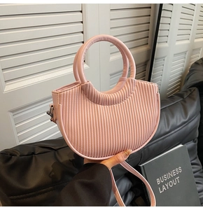 Pink pleated bucket bag detail showing the round top handle and long shoulder strap