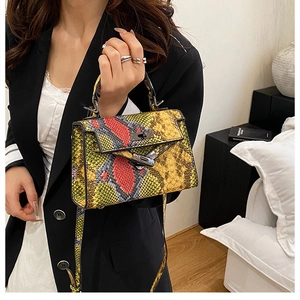 Detail view of colorful snakeskin pattern texture and metal twist lock on a small handbag