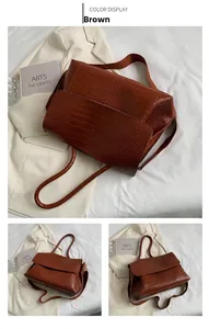 Détail du sac cabas marron à motif crocodile avec rabat et large bandoulière réglable