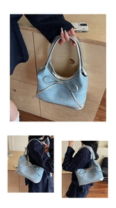Detail of denim shoulder bag with silver bow decoration and shimmering texture finish