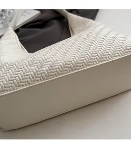 Detail showing high-quality woven texture and precise stitching on white hobo bag