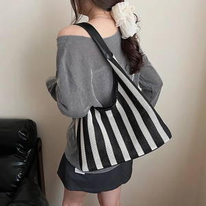 Nautical striped knit tote bag with wide shoulder strap shown in a casual lifestyle setting