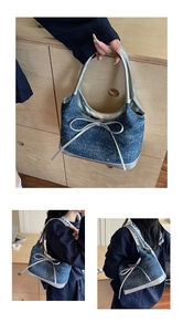 Detail of blue denim hobo bag featuring silver bow accent and metallic texture handles