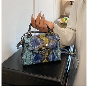 Detail of colorful snakeskin print handbag with metallic turn-lock and sturdy top handle