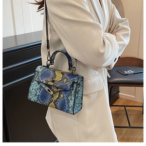 Detail of snake skin pattern texture on colorful trapezoid handbag with gold metal lock
