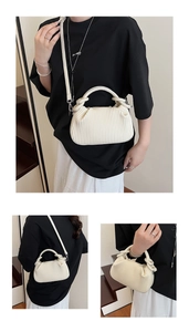 Detailed view of white pleated shell bag featuring vertical ruffles and silver hardware