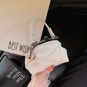 Retro white leather handbag with metal clasp and textured finish in a car interior