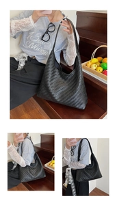 Detail of black woven leather hobo bag with textured pattern and large capacity