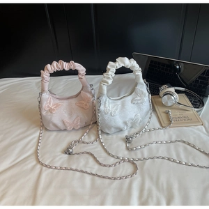 Detailed view of 3D butterfly lace tote bag with ruched handles and silver chain
