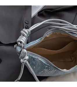 Vue macro de l'intérieur du sac en denim bleu avec fermeture éclair et détails à paillettes