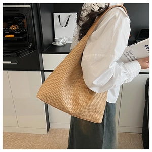 Close-up of woven hobo shoulder bag in khaki leather with dense herringbone pattern