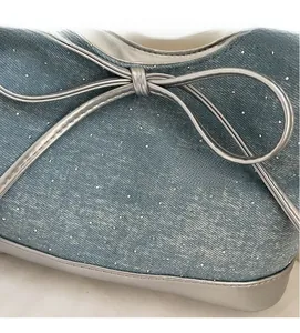 Close-up of blue denim ballet flats with silver glitter rhinestones and a metallic bow