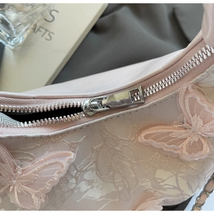 Detail of pink lace embroidery with 3D butterfly appliques and silver metal zipper