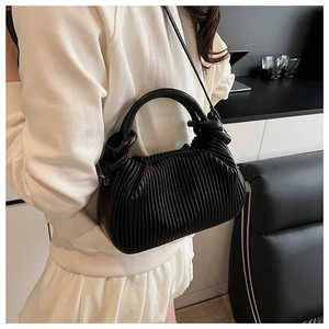 Detail of black pleated cloud bag in soft PU leather with tubular handle and strap