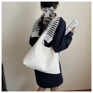 Detail of white woven texture on a large shoulder tote bag with a wide strap