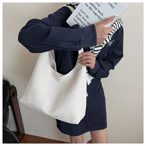 Close-up of white woven texture and leather craftsmanship on a large hobo shoulder bag