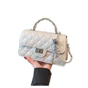 Beige quilted crossbody bag with silver chain handle and metallic turn-lock closure