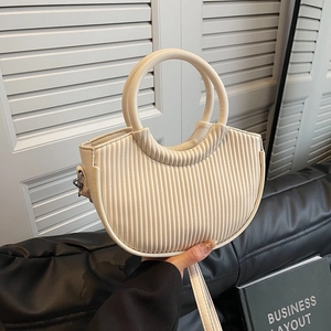 Minimalist beige pleated semi-circle handbag with circular handles and a shoulder strap