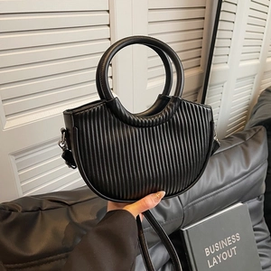 Modern black pleated crescent bag with round handle and silver metal hardware details