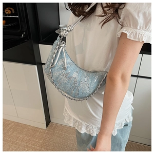 Détail du sac croissant en denim bleu clair avec paillettes argentées et bandoulière