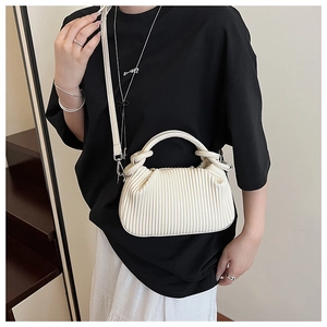 Detail of a beige pleated cloud bag showing vertical texture and adjustable strap