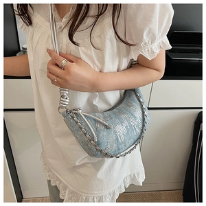 Détail du sac croissant en denim bleu clair avec paillettes argentées et bandoulière