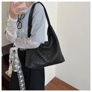 Detail of black woven leather shoulder bag showing the V-shaped hobo weave texture