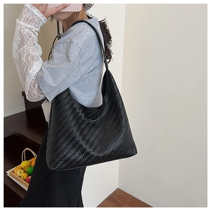 Detail of black woven shoulder bag showing premium texture and large tote capacity