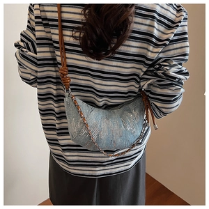 Détail du sac croissant en denim bleu avec paillettes argentées et bandoulière nouée