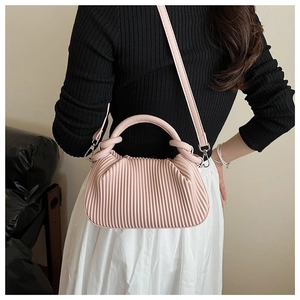 Detail view of pink pleated cloud bag with adjustable shoulder strap and silver hardware