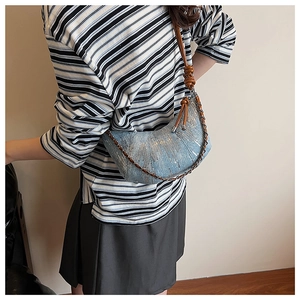 Détail du sac croissant en denim bleu clair avec paillettes argentées et bandoulière