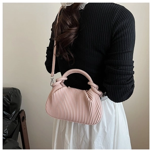 Detail view of pink pleated handbag with silver hardware and detachable crossbody strap
