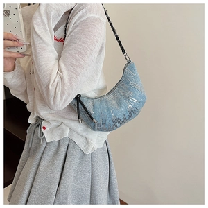 Détail du sac croissant bleu clair à paillettes avec chaîne métallique et cordon noir