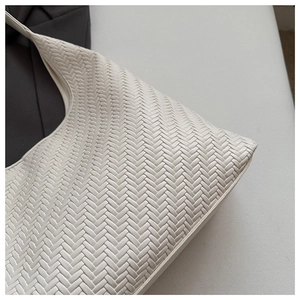 Close-up of the cream-white woven hobo bag showing detailed herringbone texture and soft material