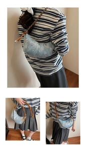 Détail du sac croissant à paillettes bleu clair avec bandoulière chaîne en cuir brun