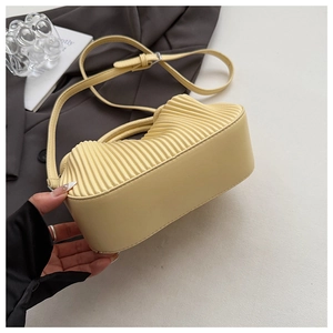 Detailed close-up of light yellow pleated cloud bag with elegant accordion textures