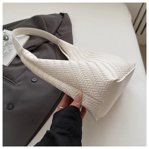Detailed view of white woven faux leather shoulder bag with seamless wide strap hobo design