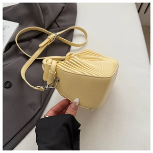 Close-up of creamy yellow pleated shoulder bag featuring elegant top handle and thin strap