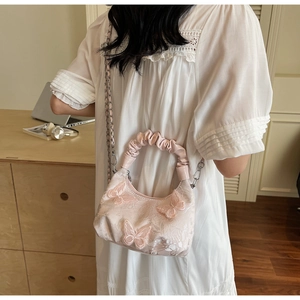 Close-up of pink lace dumpling bag with 3D butterfly embroidery and metal chain strap