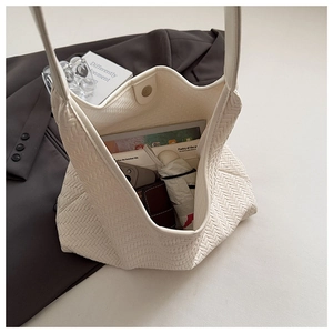 Macro view of woven tote bag interior showing large capacity for tablet and daily items