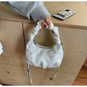 Detail of white lace crescent bag featuring 3D butterfly appliques and scrunchie handle
