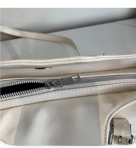 Detaillierte Draufsicht auf den glatten silbernen Reißverschluss der beigen Tote Bag