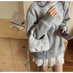 Detailed close-up of white butterfly jacquard handbag with elegant pleated cloud handle