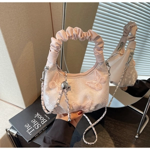 Detailed embroidery of 3D butterfly on a pink satin fabric bag with chain strap