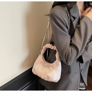 Close-up of pink bag featuring 3D butterfly embroidery and a ruched cloud handle