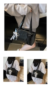Detail der glänzenden schwarzen Tote Bag mit Spitzen-Schleifen-Anhänger und Perlenkette