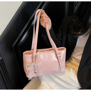 Detailansicht der pinkfarbenen Lackleder-Tasche mit Spitzenschleife und Perlenanhänger