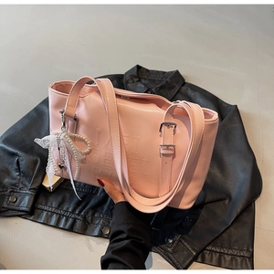 Rosa Modetasche mit Prägung, Perlenanhänger und Spitzenschleife auf Lederjacke