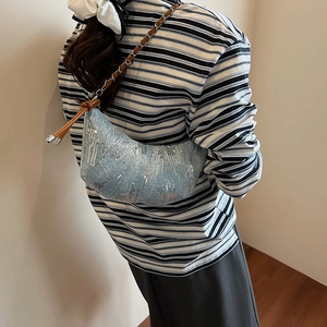 Sac hobo bleu à paillettes avec bandoulière chaîne porté par un mannequin